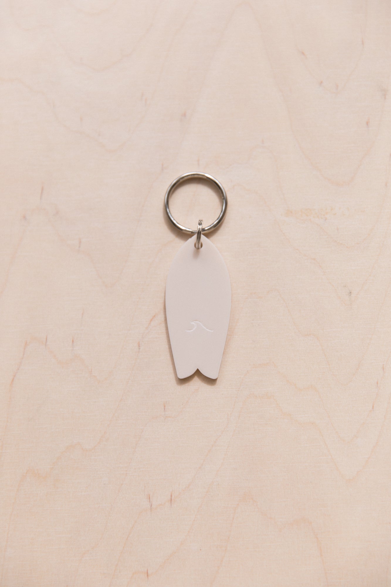 Surf keychain with wave pattern in neutral tones