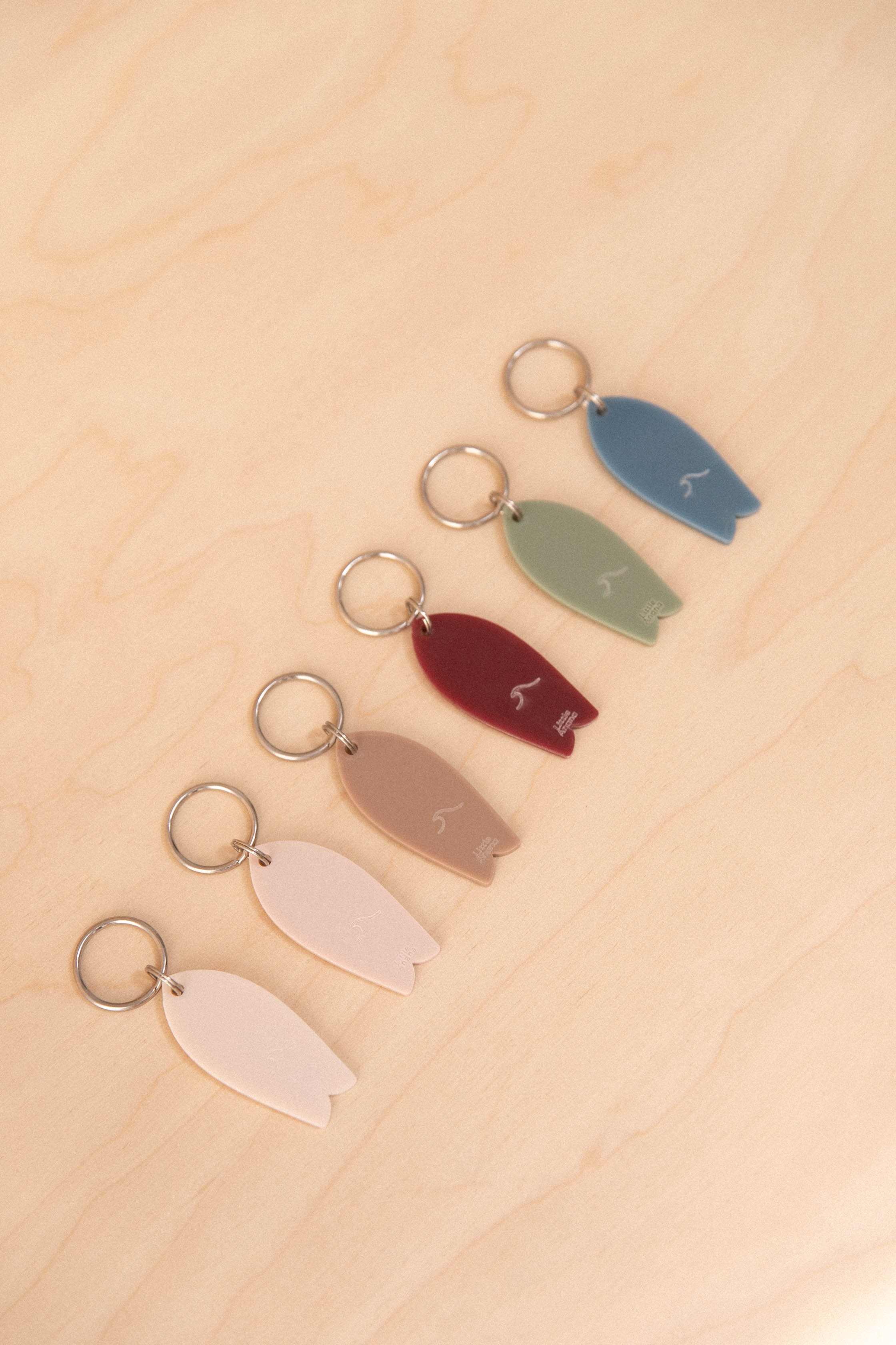 Surf keychain with wave pattern in neutral tones